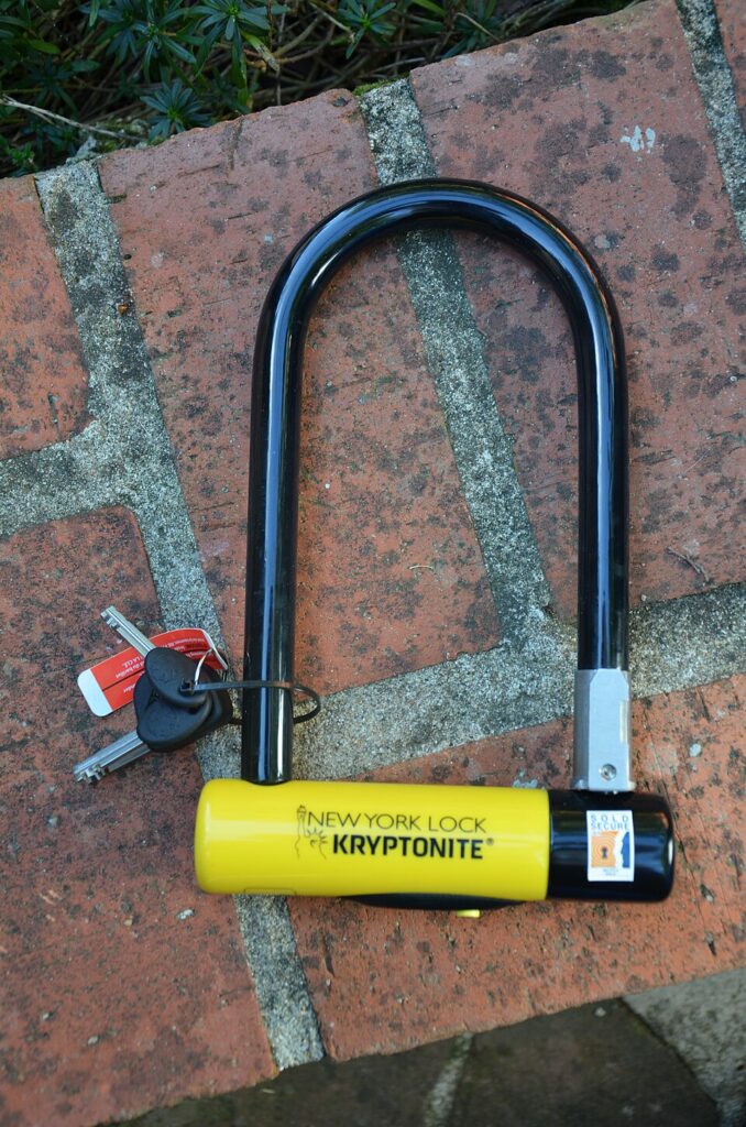 Closed U lock with keys on a brick background.